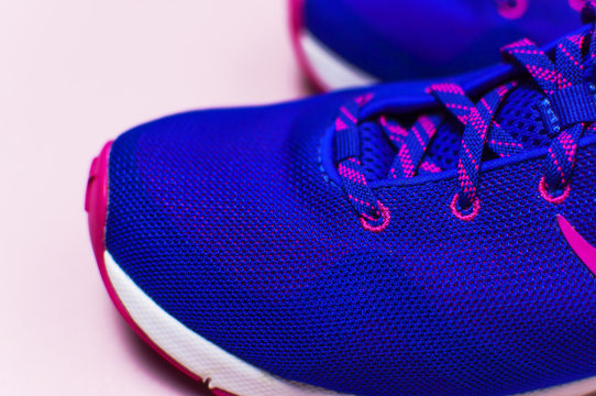 Ultra blue violet pink female sneakers on pastel pink background flat lay top view with copy space. Sports shoes, fitness, concept of healthy lifestile, everyday training. 