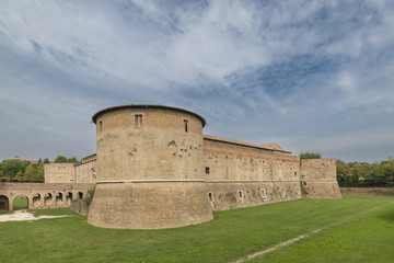 Fototapeta na wymiar the rocca, or castle, immersed in the green of the military architecture of the fifteenth century. square, with four great cylindrical towers, the various slits and ports for cannon