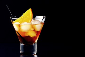 Whiskey cocktail glass with lights background. Alcoholic cocktail isolated on black