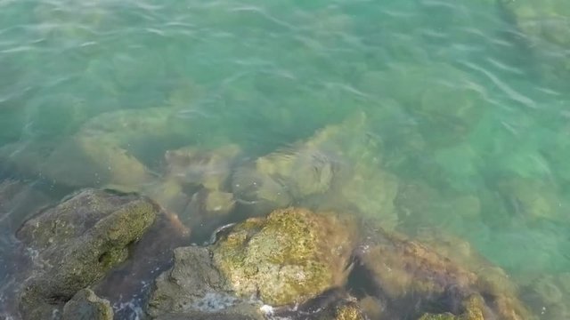 T&uuml;rkei, Aeg&auml;is., Alanya - 4. September 2018: Felsen am Quai seicht umsp&uuml;lt von warmen Meerwasser (32 Grad Celsius), Originalton