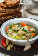 Fresh white fish soup with carrots, potatoes, onions, herbs and spices. Rustic style