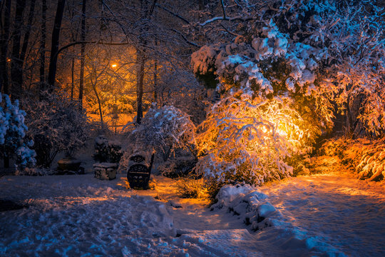 Beautiful winter scene with lots of snow and a bench on a silent night in a park