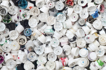 A large number of caps from cans of aerosol paint for graffiti. Smeared with colored paint nozzles...