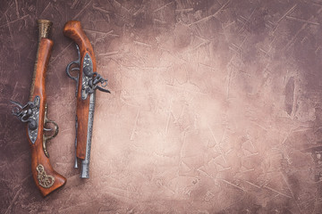 Two vintage duel pistols on wooden background - obrazy, fototapety, plakaty