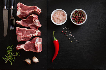 Raw fresh Lamb Meat ribs and seasonings on black stone background