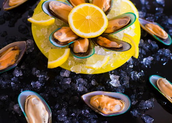 Fototapeta na wymiar Food. mussels, vegetables, yellow plate, black background, ice
