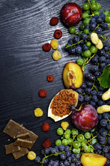 food rich with resveratrol, grapes, plums, goji, peanuts, cranberry,raspberrys chocolate on black...
