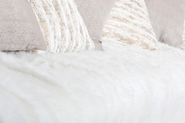 Many pillows lie on the couch, which is covered with a large plush veil