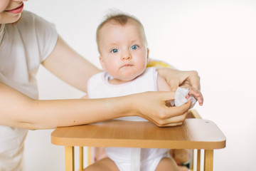 Mum wipes baby's arm after feeding