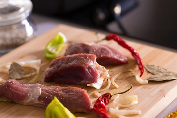 Food. pieces lamb, peppers and onions, wooden board