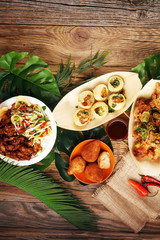 various street food with pani puri, chicken wings and coxinha on rustic background. balinese nasi...