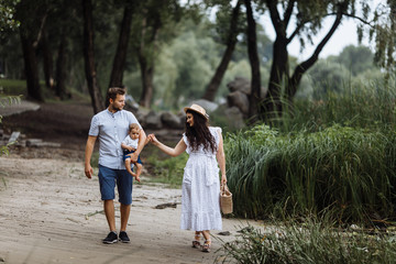 Fototapeta premium Amazing young couple with small son in the park