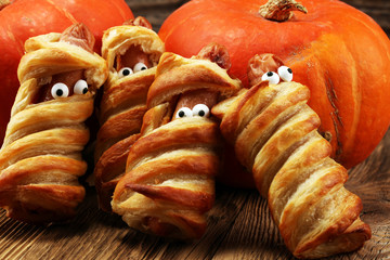 Mummy sausages scary halloween party food decoration wrapped in dough.