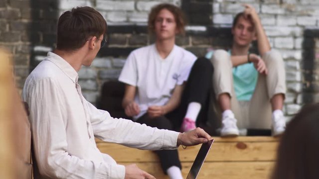 Young man in checkered pants opens netbook
