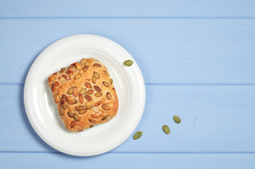 Bun with pumpkin seeds in plate