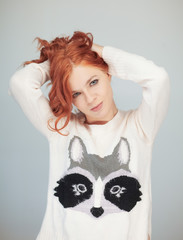 beautiful woman with perfect red curly hair and make up in a wintry christmas knit sweater