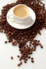 Cup of coffee surrounded by coffee beans