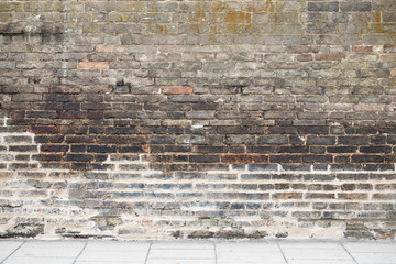 Old brown  brick wall with tile road