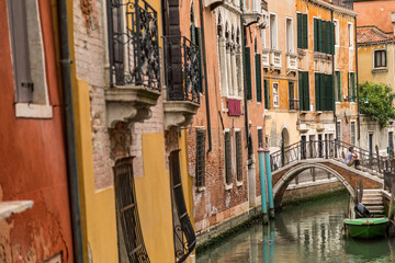 Venice, Italy, the lagoon town, viewing old alleys along small canals with historic buildings at a sunny day in summer.