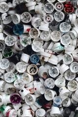 A large number of caps from cans of aerosol paint for graffiti. Smeared with colored paint nozzles...