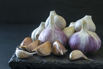 Garlic on a black serving board.