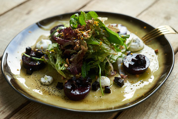 Salad with roasted beetroot, spinach, soft goat cheese on wooden table, top view, copy space. 