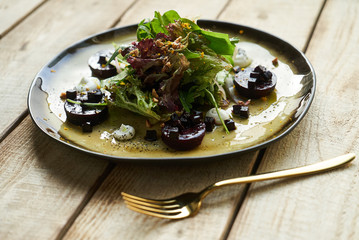 Salad with roasted beetroot, spinach, soft goat cheese on wooden table, top view, copy space. 