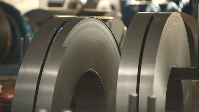 hook the coil for the tap with your hands and raise. steel coils lie side by side. create profiles. rolls of galvanized steel. rolls of sheet metal.