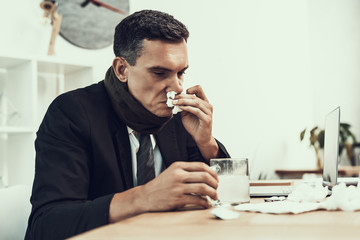 Sick Man in Suit with Scarf Sitting in Office.