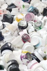A large number of caps from cans of aerosol paint for graffiti. Smeared with colored paint nozzles...