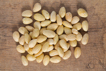 peeled almonds on wooden surface