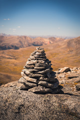 Fototapeta na wymiar A large cairn marking a trail in Colorado with mountains in the background. 