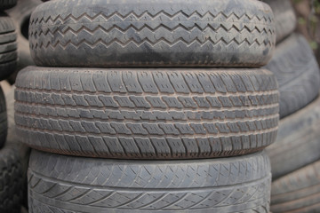 close up of a pile of used black dusty tires, outdoors, on street in the Gambia, with natural light