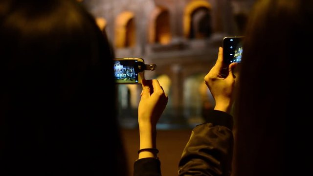 Coliseum at Night. Girls Korean, Japanese, Chinese browse photos at camera