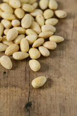 peeled almonds on wooden surface