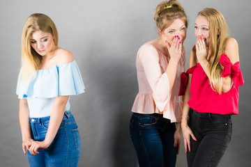 Woman being gossiped by two females