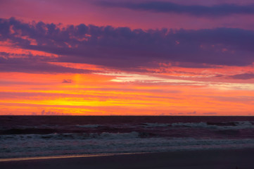 Lilac and red shades of water and sky at sunrise. Lilac sky at sunset.