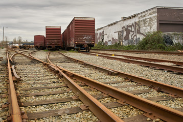 Fototapeta na wymiar Urban Railroad Tracks and Cars. Railroad tracks running through an urban centre.
