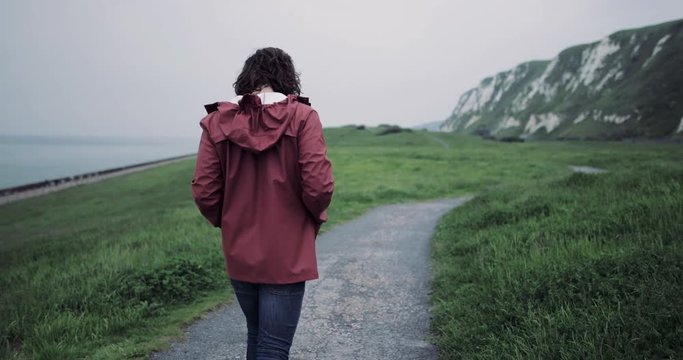 Millennial walking on a rural path looking at landscape