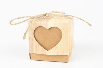 Boxes with the word love on a white table. A gift in a box with a heart cut out.