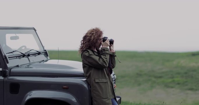Millennial female taking photo of scenic landscape