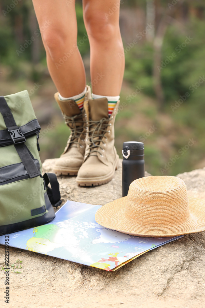 Sticker Camping equipment and woman in boots on rock, closeup