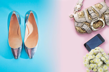 Modern fashion accessories young women shoes handbag shoes silver gradient blue bouquet flowers pink background.