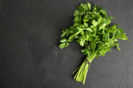 Fresh green parsley and space for text on black background, top view