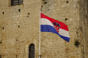 Croatian flag displayed against limestone outer walls