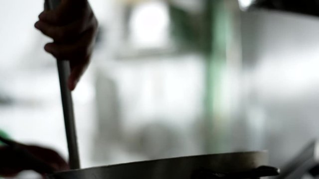 Close up of someone stirring a pot on a burner in a Mexican food restaurant
