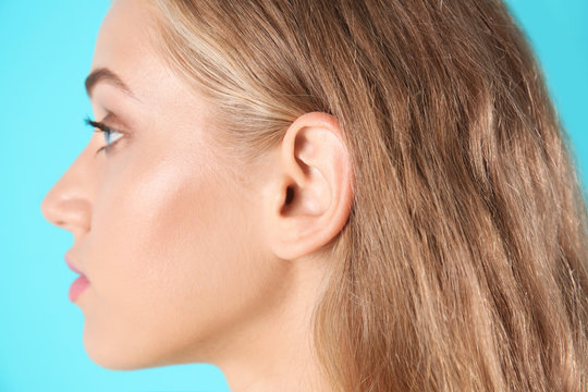 Young woman on color background, closeup. Hearing problem