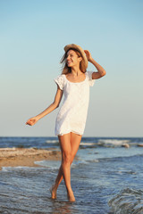 Fototapeta na wymiar Young woman enjoying sunny day on beach