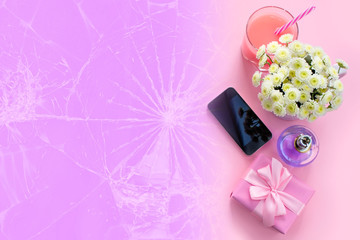 Composition flat lay gift to a woman Modern gadget mobile phone glass cocktail perfume bouquet of flowers Preparing for the holiday surprise gift box Top view pink background