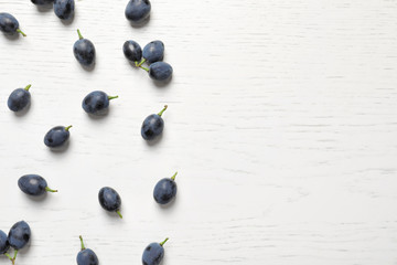 Fresh ripe juicy grapes on white wooden background, top view. Space for text